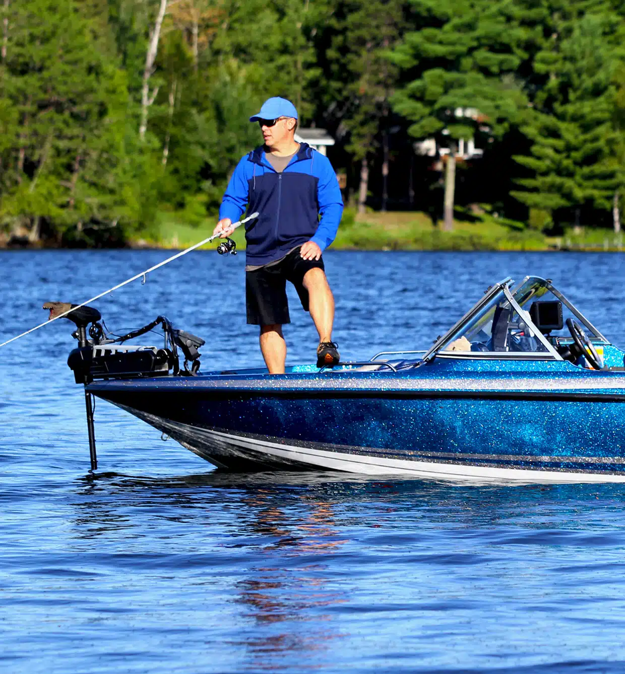 a man riding on the back of a boat in the water